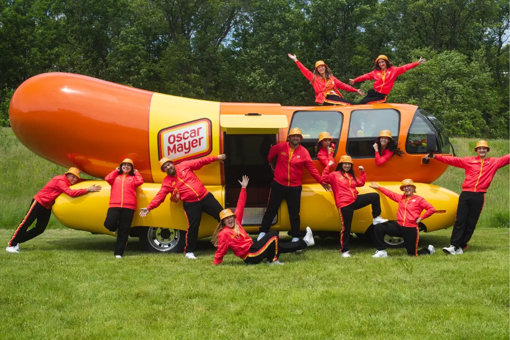 The Oscar Mayer Wienermobile with its Hotdogger team