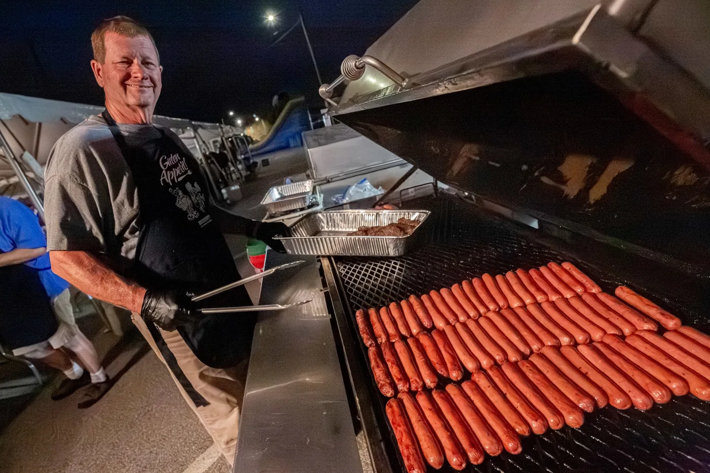 Volunteer cooking hot dogs during Oktoberfest
